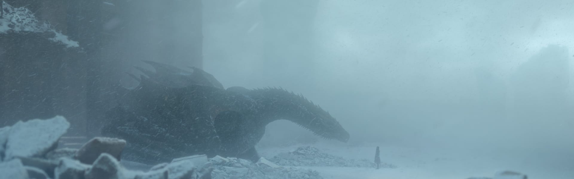 A dragon and a person in the snow from Game of Thrones