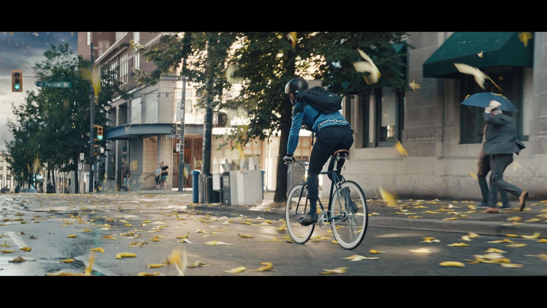 A cyclist rides down a banana-strewn street
