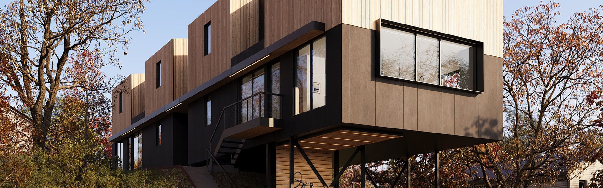 Front view of a cantilevered house. The house is clad in wood on the top half, painted black on the bottom half