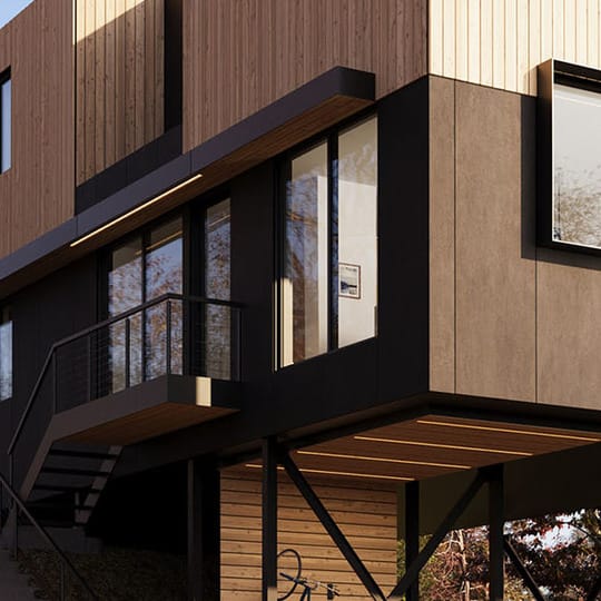 Front view of a cantilevered house. The house is clad in wood on the top half, painted black on the bottom half