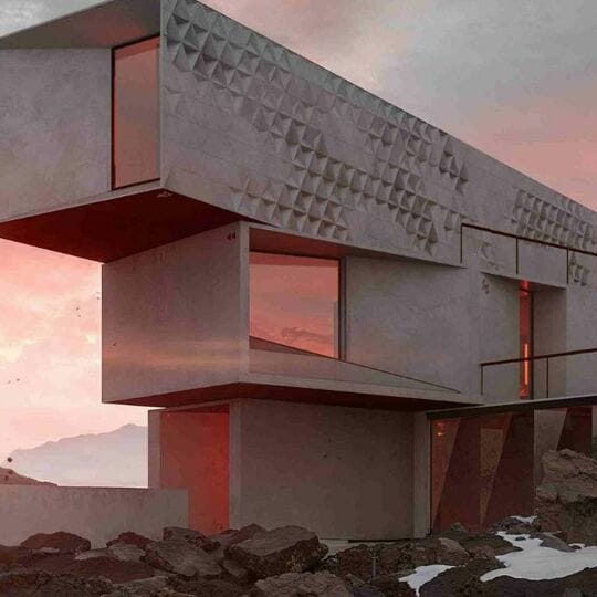 A still from xoio’s Unboxing animation. A cloaked figure stands on jagged rocks next to a stark, architecturally designed house. A sunset illuminates the windows, making them glow red.