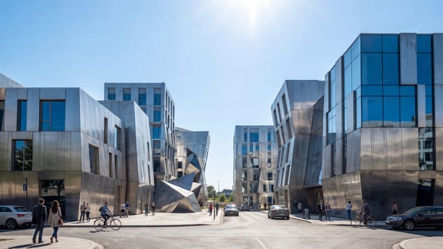 Contemporary metal-and-glass buildings visualized together as a connected city block.